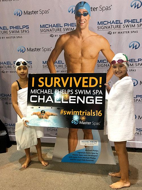 Two girls proudly show they survived the Michael Phelps Swim Spa Challenge